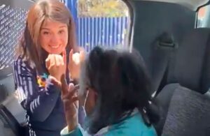 Con lenguaje de señas mujer policía explica a abuelita el proceso de vacunación
