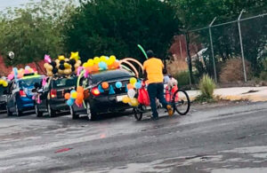 Padre expresa amor a su hijo adornando su triciclo para participar en caravana escolar